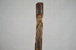 hiking stick with a face carving