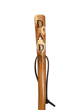 Walking stick with "DAD" carved down the handle and leather strap.