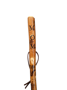 Walking stick with "MOM" carved down the handle and leather strap. 