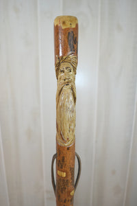 dark wood walking stick with face