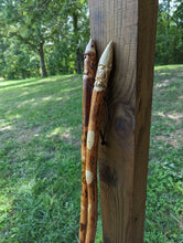 Outdoor picture of walking sticks with a Gnome carved at the top.