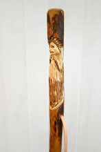 walking stick with mountain man carving on it 