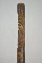 Side view of Wood Spirit face carved on a walking stick 